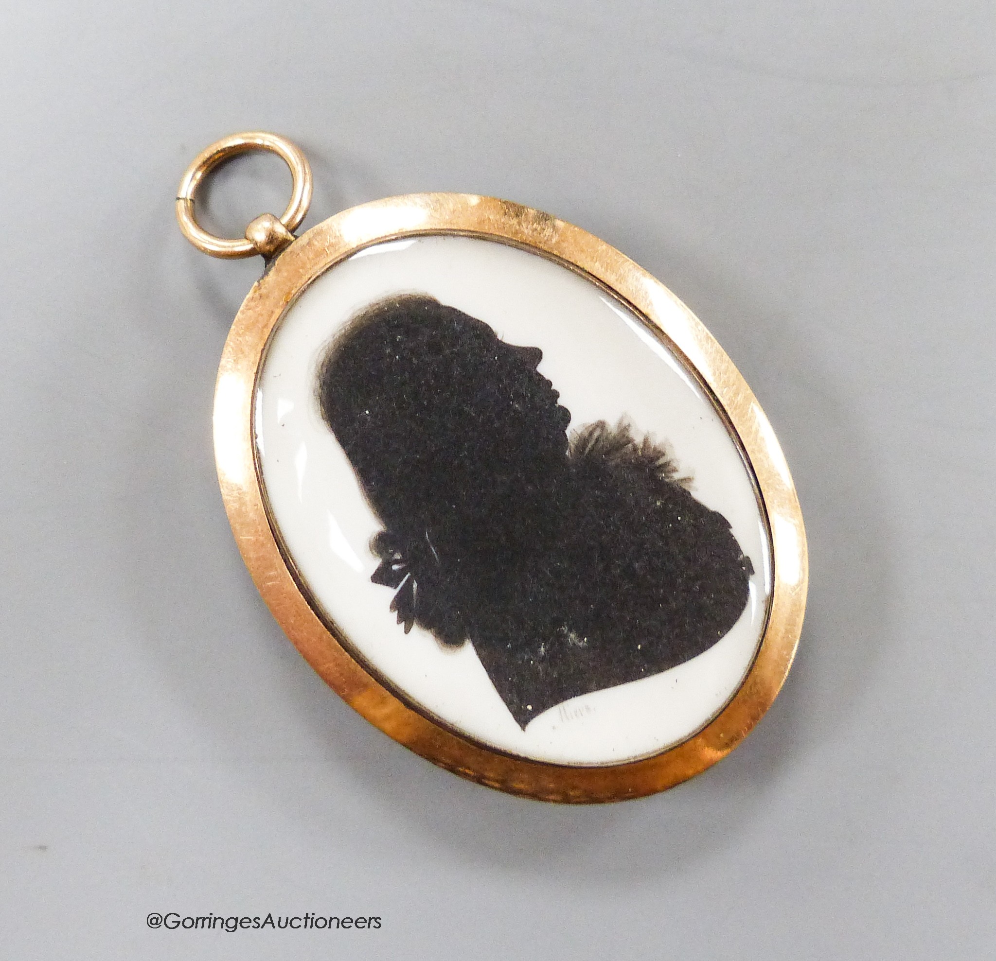 A yellow metal mounted oval double silhouette by John Miers, lady to one side and a larger gentleman to the other, both signed, 29mm, overall 34mm.